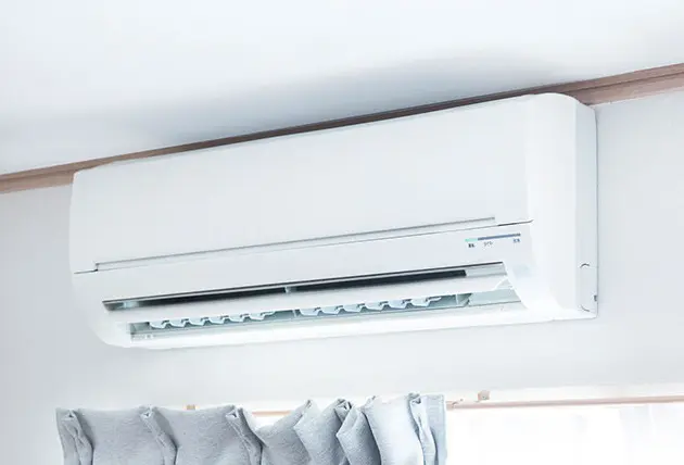 a white interior heat pump installation above a window on a white wall